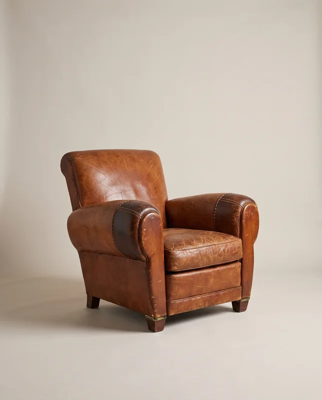 Fauteuil « Club rafistolé », fauteuil club en cuir aux accoudoirs reprisés